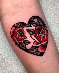 a heart shaped tattoo with roses on it