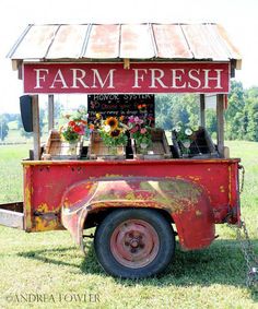 an old farm fresh truck is parked in the grass with sunflowers on it