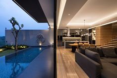 a living room filled with furniture next to a swimming pool in a modern style home