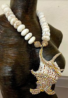 Here's another piece from my private collection, albeit it new and unworn. I bejeweled an exotic shell with gold aurora borealis rhinestones and attached it to an understated, yet rich and posh off white magnesite rondelle necklace. This piece adjusts from 21-25" and closes with gold tone hardware, a lobster claw clasp and a 4" extender chain. A fancy beaded dangle is suspended off the extender chain which adds interest and drama to the back. The single strand necklace consists of magnesite rond Bohemian White Jewelry With Rhinestones, Beach Jewelry With Rhinestones And Crystal, Beach Crystal Jewelry With Rhinestones, Luxury Unique Shell Necklaces, Luxury Handmade Shell Pendant Necklace, Beach Crystal Rhinestone Jewelry, Luxury Shell-shaped Beach Necklaces, Rondelle Necklace, Luxury Statement Beads, Gems, And Cabochons