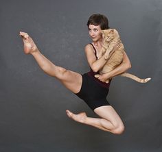 a man with a cat on his back is in the air while he holds it up