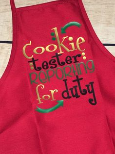 a red apron with the words cookie tester preparing for duty on it's side