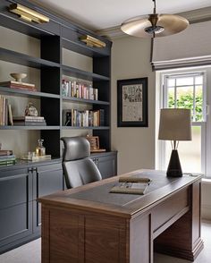 a home office with built in bookshelves and desk