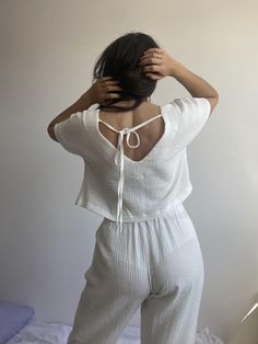 "Women's muslin pajamas made from 100% organic cotton. The handmade night set is the best gift for her. The set includes: straight-cut trousers and a T-shirt with a cut-out at the back with ties and a dropped shoulder. Experience the highest quality of our pajamas. Homewear is a unique type of product designed to give a feeling of comfort, coziness and warmth. The natural fabric is suitable for all temperatures, providing the breathability your skin needs. This is an indispensable thing in your wardrobe, which for many years will delight you with a consistently stunning appearance. The design is cute and fits most body types, making you feel and look amazing. Our advantages: - Unique design;  -Sustainable Fabrics: I only use sustainable fabrics to create our pajamas, making them safe for h White Cotton V-neck Sleepwear, Organic Cotton Sleepwear For Spring, Cotton Matching Set Tops For Bedtime, Cotton V-neck Relax Fit Sets, Relaxed Fit Cotton V-neck Sets, White Cotton Sleepwear For Summer, White Matching Set Tops For Loungewear, White V-neck Bedtime Set, Summer Cotton Sleepwear Matching Set