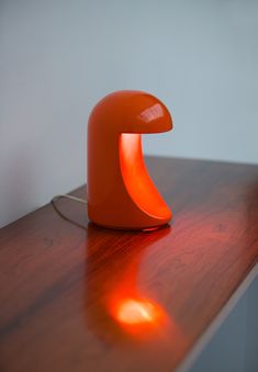 an orange lamp sitting on top of a wooden table