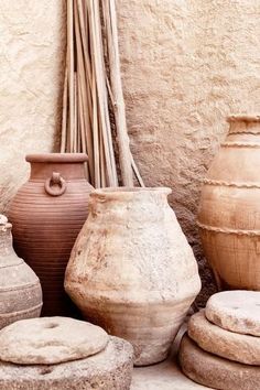 several vases are sitting next to each other on the ground in front of a wall