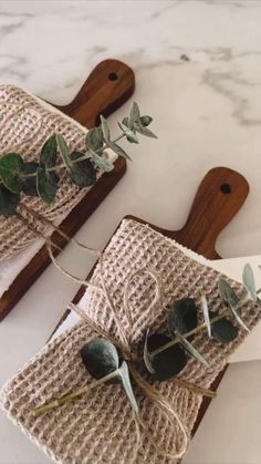 two pieces of cloth with green leaves tied to them on top of a cutting board