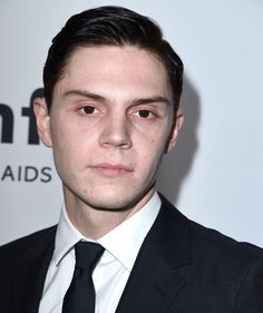 a young man in a suit and tie posing for the camera at an awards event