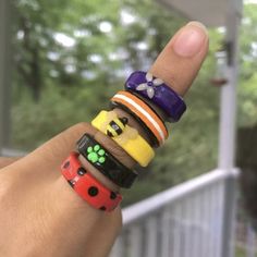 a person holding up a stack of bracelets on their fingers with the thumb in the air