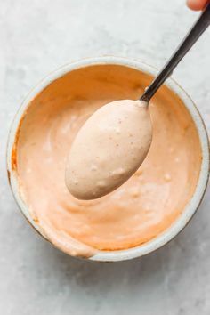 a spoon in a bowl filled with peanut butter