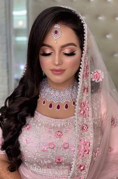 a woman wearing a pink bridal outfit