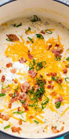 a blue pot filled with potato soup and topped with bacon, cheese and green onions