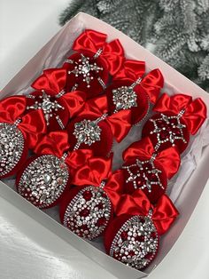 a box filled with lots of red bows and brooches on top of a table