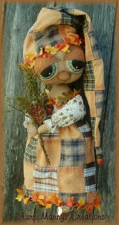 a stuffed animal wearing a plaid coat with leaves on it's head