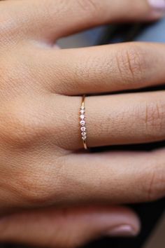 a woman's hand with a diamond ring on it