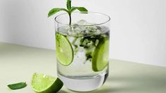 a glass filled with ice and lime slices