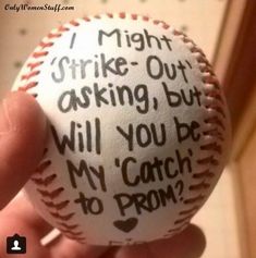 a hand holding a baseball with words written on it