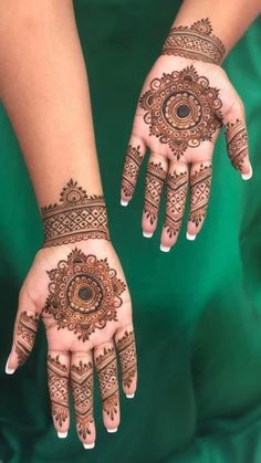 two hands with henna designs on them