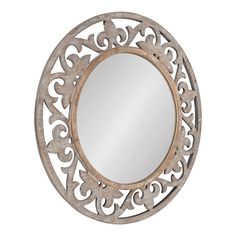 a round mirror with an ornate design on it