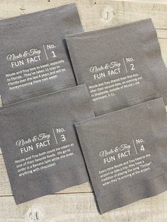 four gray napkins with white writing on them