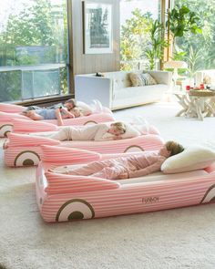 three children laying on inflatable beds with pillows