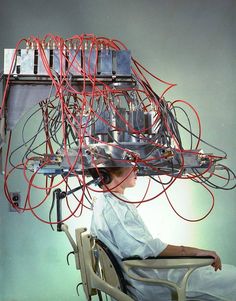 a woman is sitting in a chair with wires attached to the back of her head