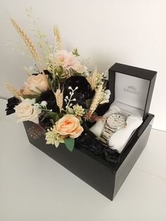 a black box with flowers and watches in it