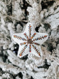 a snowflake ornament hanging from a christmas tree