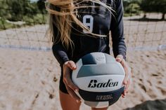 a woman holding a volleyball in her hands