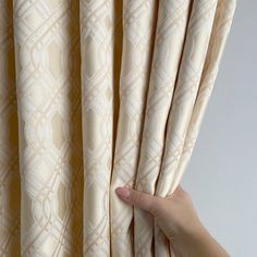 a hand is holding the curtain in front of it