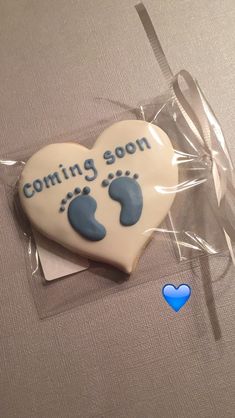 a cookie shaped like a baby's foot with the words coming soon on it