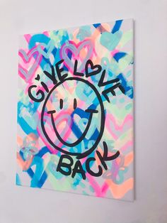 an art piece with the words smile back on it in black and pink, blue, yellow and green colors