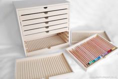 two wooden drawers with colored pencils in them