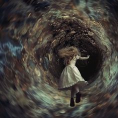 a girl in white dress flying through a spirally tunnel with her arms spread out