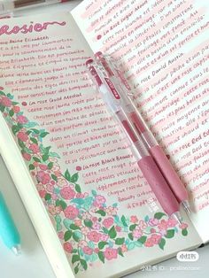 a pink pen sitting on top of an open notebook