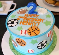 a blue birthday cake with sports themed decorations