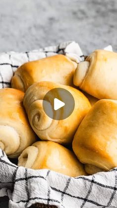 a basket filled with rolls sitting on top of a table