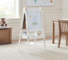 a child's easel with a drawing board on it in front of a window