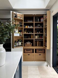 an organized pantry with wooden shelves and drawers