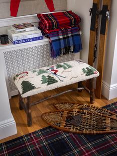 a wooden bench sitting on top of a hard wood floor next to a pile of blankets