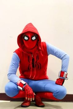 a person in a spider man costume sitting on the ground