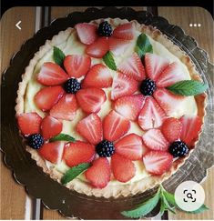 a pie with strawberries and blackberries on top