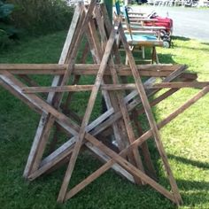 a large wooden star sitting on top of a lush green field