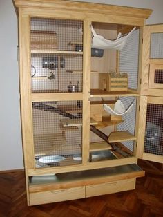 a large wooden cabinet with glass doors and shelves in the center, filled with bird cages