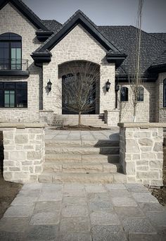 a house with stone steps leading up to the front door and entry way that leads into it