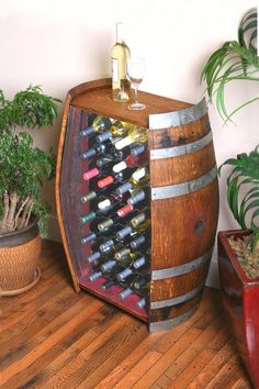 a wooden barrel filled with lots of wine next to potted plants and a planter