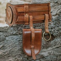 two leather wallets sitting on top of a tree