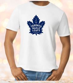 This AWESOME Toronto Maple Leafs t shirt is hand pressed with care. All of our items are hand made to order, using premium quality heat press vinyl, on super soft Gildan shirts, using 100% cotton and unisex sizing.    Check out the colour chart in the photo section we have done this t shirt on white so that it shows up really well, and the size chart to make sure you have the size you need. This t shirt for Toronto Maple Leafs is sure to become your new favourite graphic t shirts. Great for yourself or as a gift. If you do not see the size, colour or brand of t shirt you would prefer reach out to us and we will do our best to accommodate you. We also offer custom orders, so if you have a great idea for a design, get in touch and we'll see what we can do! Thanks for stopping by Blended and Sports Fan T-shirt With Screen Print And Crew Neck, White T-shirt With Sublimation Print For Fans, Casual T-shirt With Heat Transfer Vinyl For Sports Events, Crew Neck Shirt With Screen Print For Fans, Pre-shrunk White Sports Fan T-shirt, White Pre-shrunk Sports Fan T-shirt, White Sports Fan Shirt With Graphic Print, White Graphic Print Sports Fan Shirt, White Screen Print Shirt For Fan Merchandise