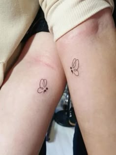 two people with matching tattoos on their arms