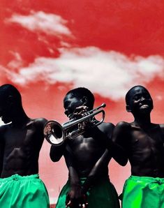 three men with black skin and green skirts are holding a trumpet in front of a red sky